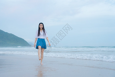 深圳西冲沙滩上的少女玩水图片