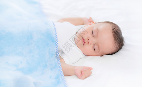 床上玩电脑盖着毯子的婴儿在床上熟睡背景