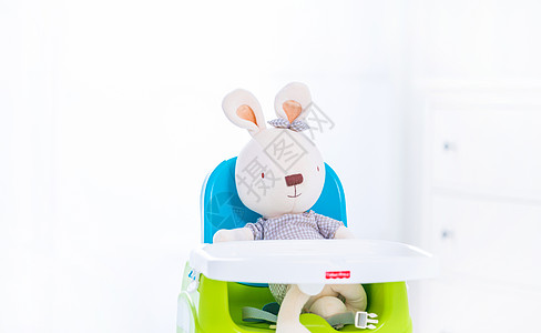 可爱的玩具兔坐在婴儿椅上图片
