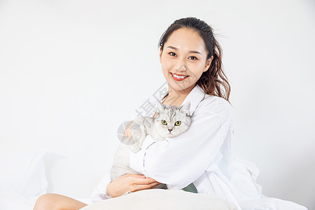 年轻美女和宠物猫在家嬉戏背景图片