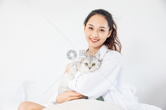 年轻美女和宠物猫在家嬉戏图片