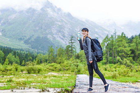 户外登山美女喝水休息图片