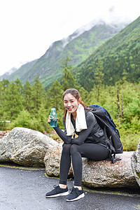 户外登山美女喝水休息图片