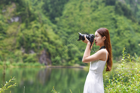 女生手拿相机美女旅行相机拍照背景