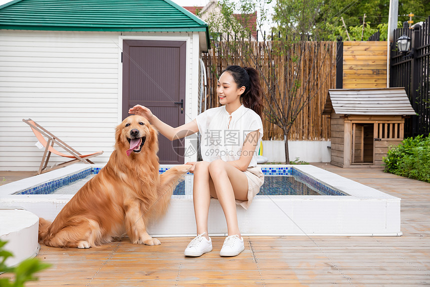 美女与宠物狗院子里嬉戏握手图片