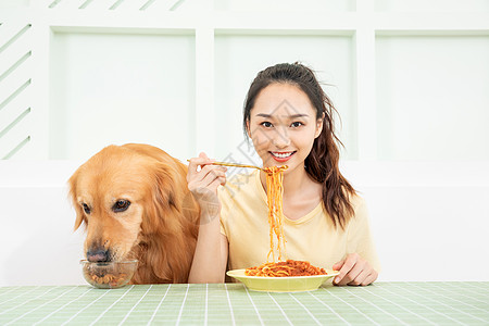 美女主人和宠物狗一起吃饭图片