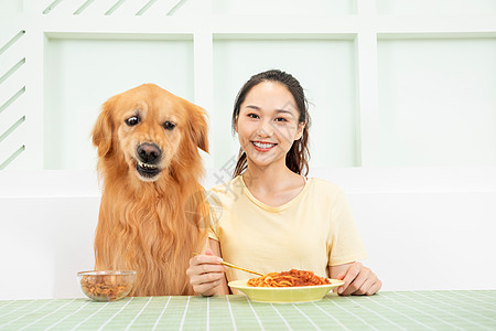 美女主人和宠物狗一起吃饭图片