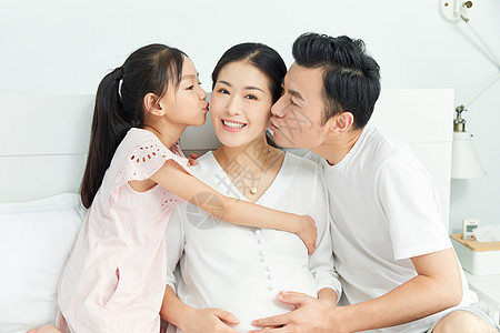 小女孩和爸爸一起亲吻孕妇妈妈图片