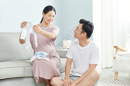 孕妇和丈夫在家收拾婴儿服饰图片