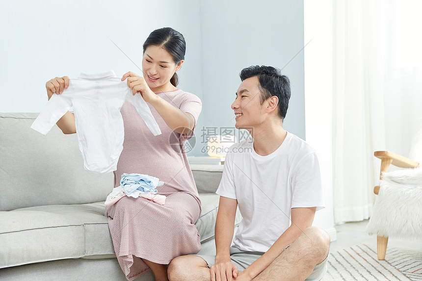 孕妇和丈夫在家收拾婴儿服饰图片