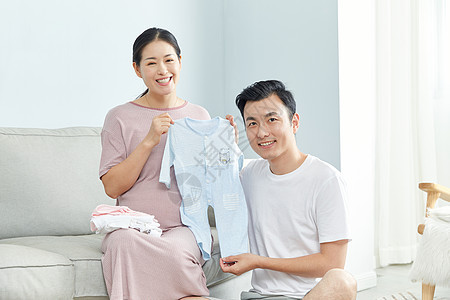 孕妇和丈夫在家收拾婴儿服饰图片