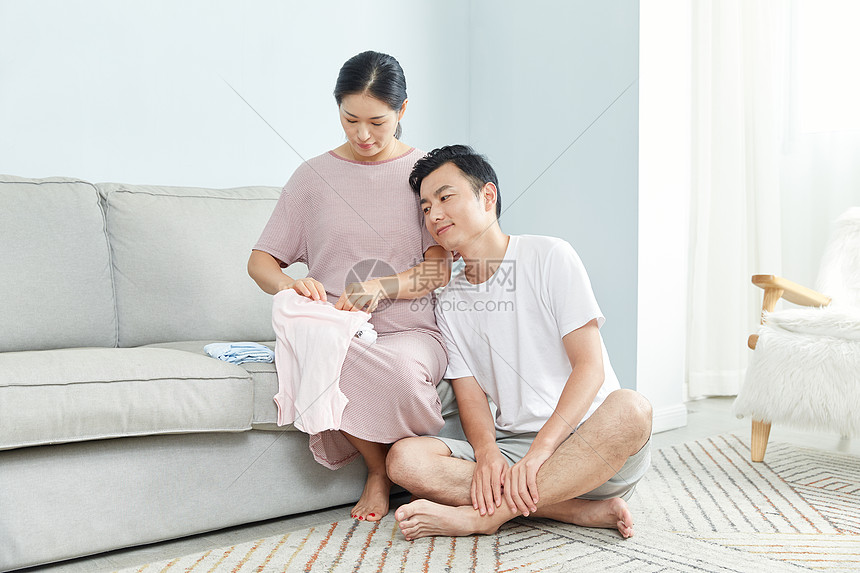 孕妇和丈夫在家收拾婴儿服饰图片