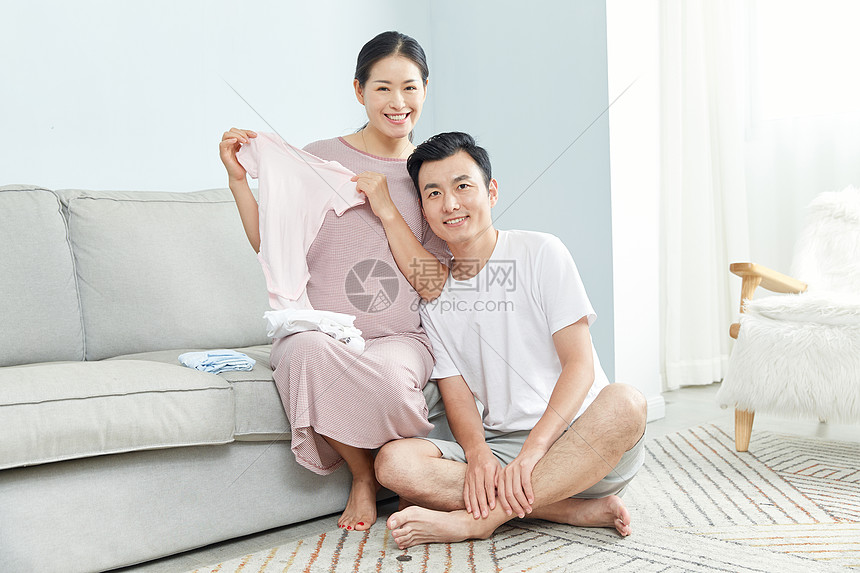 孕妇和丈夫在家收拾婴儿服饰图片