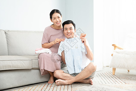 孕妇和丈夫在家收拾婴儿衣服中国人高清图片素材