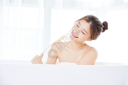 年轻女性在浴缸洗澡背景图片