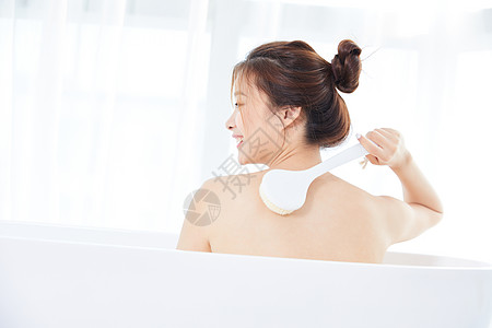 年轻女性在浴缸洗澡背景图片