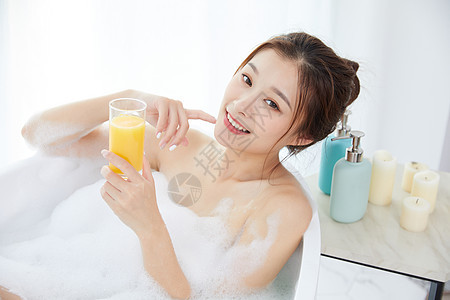 美女躺在浴缸洗泡泡浴喝果汁图片