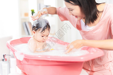 坐着的小宝宝妈妈给宝宝洗泡泡浴背景