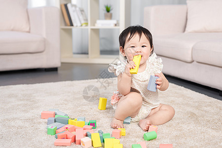 小孩在客厅女婴在地毯上玩积木背景