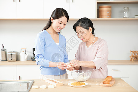 妈妈和女儿一起做月饼高清图片