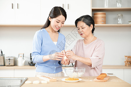 母女温馨妈妈和女儿一起做月饼背景