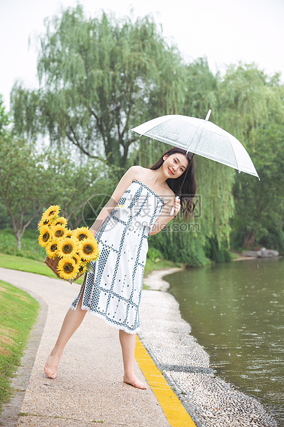 雨中撑伞提花的少女图片