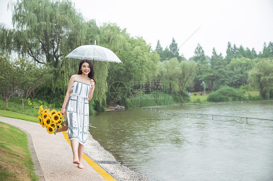 雨中撑伞提花的少女图片