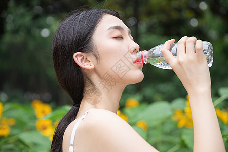 向日葵中的少女在喝水高清图片