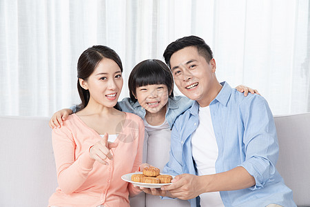 爸爸妈妈和儿子一起吃月饼高清图片