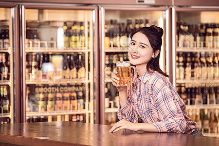 年轻美女酒吧喝啤酒背景图片