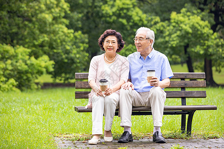 幸福老人老年夫妇坐在公园长椅休息背景