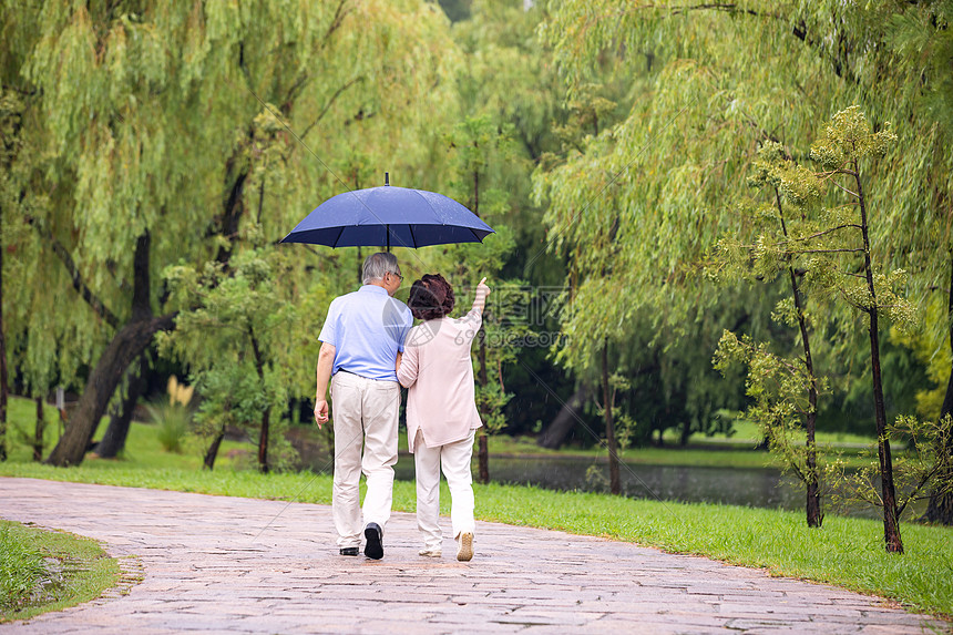 老年夫妇雨中散步背影图片