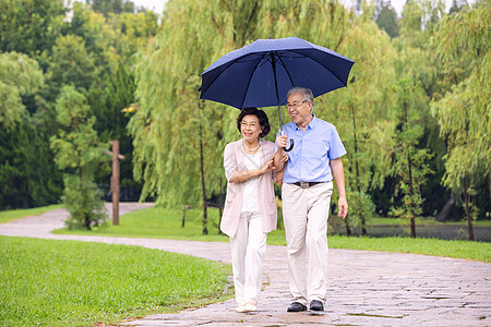 老年夫妇在公园雨中散步图片