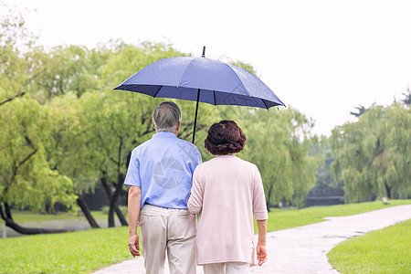 老年夫妇雨中散步背影图片