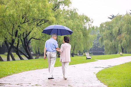 一对老人背影老年夫妇雨中散步背影背景