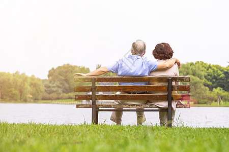 老年幸福老年夫妇坐在公园长椅背影背景