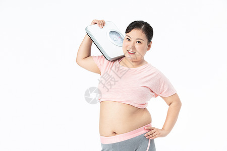 运动身材胖女孩手拿体重秤背景