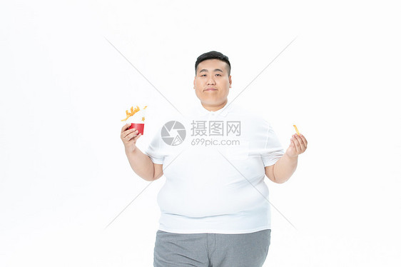 青年肥胖男性吃汉堡和薯条图片