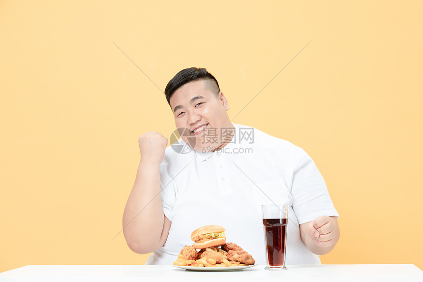 青年肥胖男性吃炸鸡加油手势图片