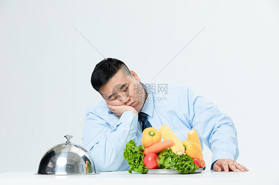 肥胖商务男性吃蔬菜厌烦图片