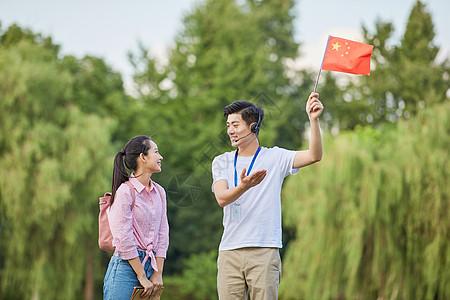 飘扬的旗子男性导游给游客做介绍背景