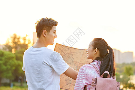 中国人情侣拿着地图旅行背影背景