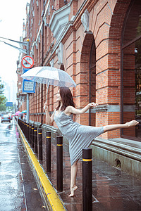 雨中舞蹈在街上撑伞跳舞的女性背景