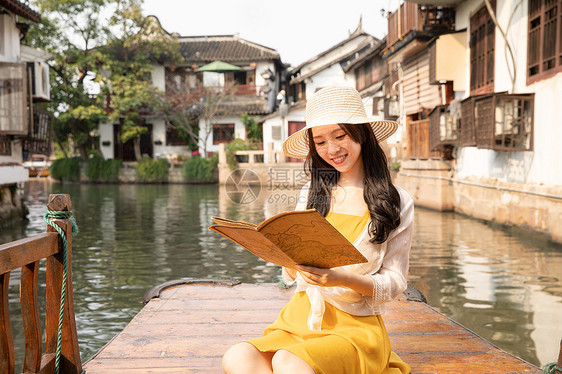 年轻美女乘船郊游看地图图片