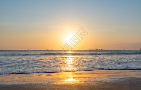 金色海浪巴厘岛金巴兰海滩的日落美景背景