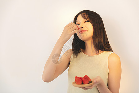 居家女性吃草莓背景图片
