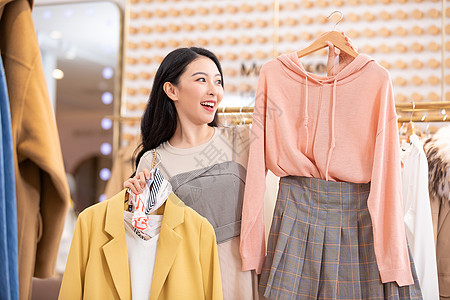 逛街买衣服年轻美女逛街购物挑选衣服背景