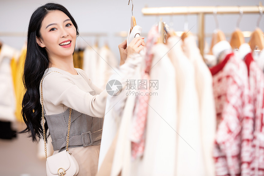 年轻美女商场购物挑选衣服图片