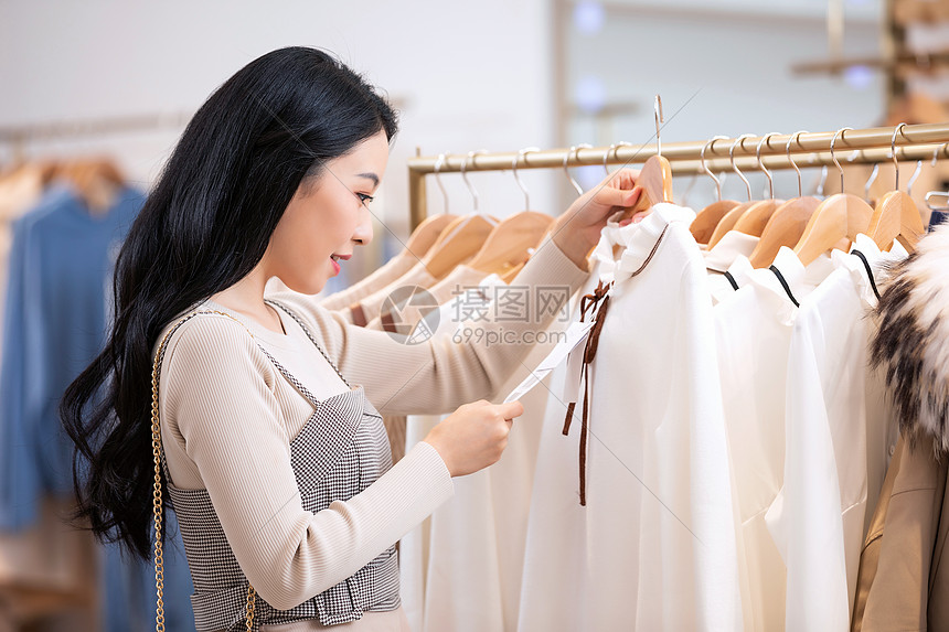 年轻美女商场购物挑选衣服图片