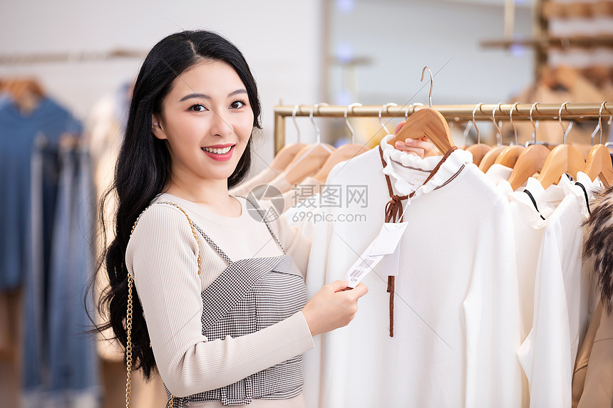 年轻美女商场购物挑选衣服图片